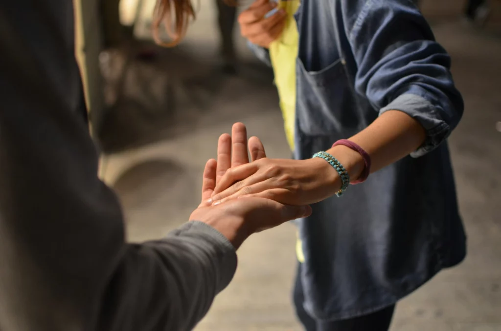 Une personne tend sa mère vers une autre personne afin de lui apporter son aide. Cette image illustre la page "Qui suis-je ?"